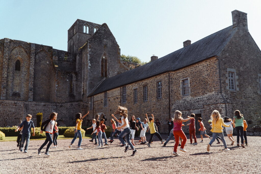 Enfants dansant devant la cour monastique