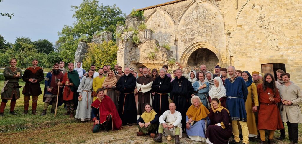 Le collectif de la conférie normande en costume devant l'abbaye de Longues-sur-Mer