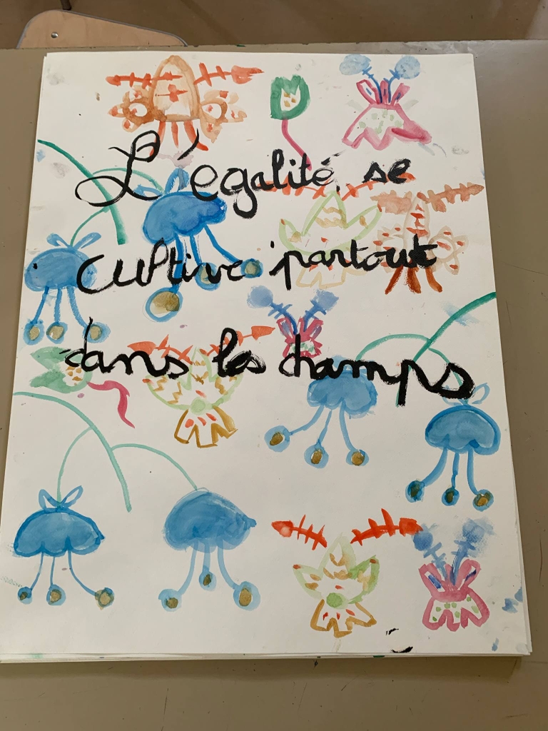 Création d'un(e) élève lors d'un atelier aquarelle à l'abbaye. sur fond de fleurs se lit la phrase : L'égalité se cultive partout dans les champs.
