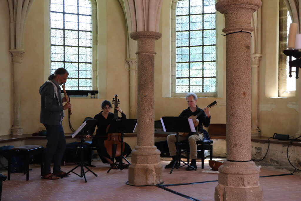 Concert dans la salle capitulaire de l'abbaye de Hambye. 3 musiciens se tiennent dans l'abside : flute, viole de gambe, archiluth