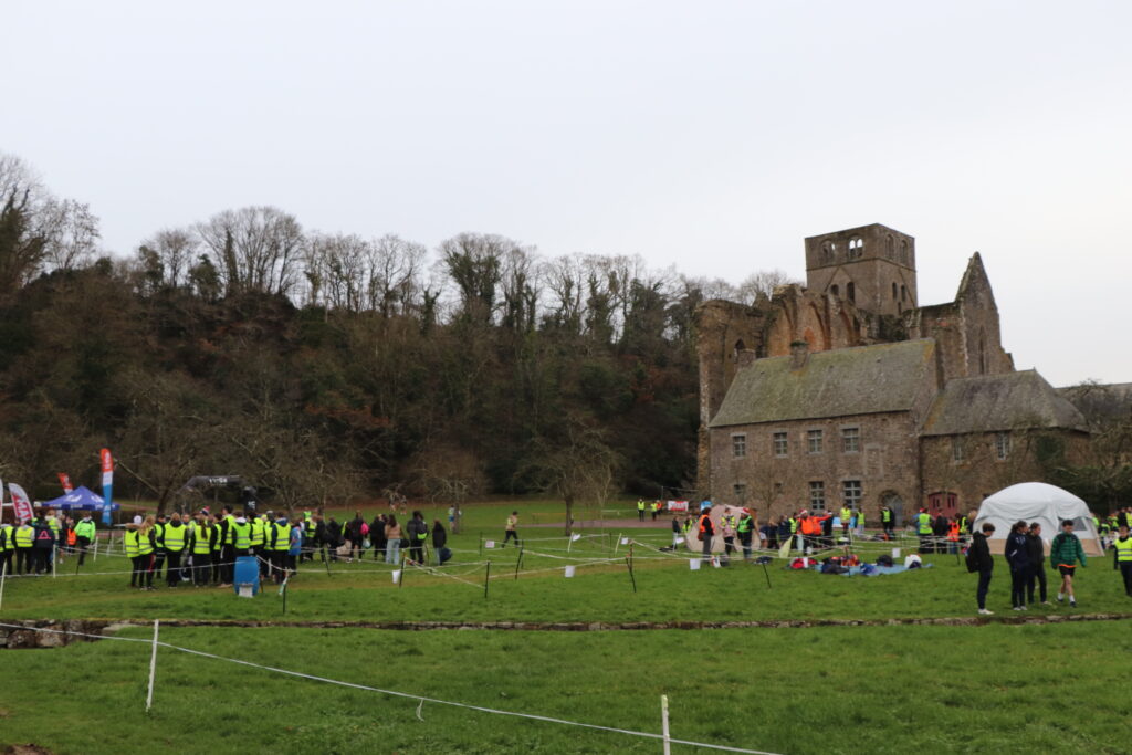Les participants du trail semi-nocturne attendent le départ dans le verger de la basse cour de l'abbaye. Il fait encore jour.