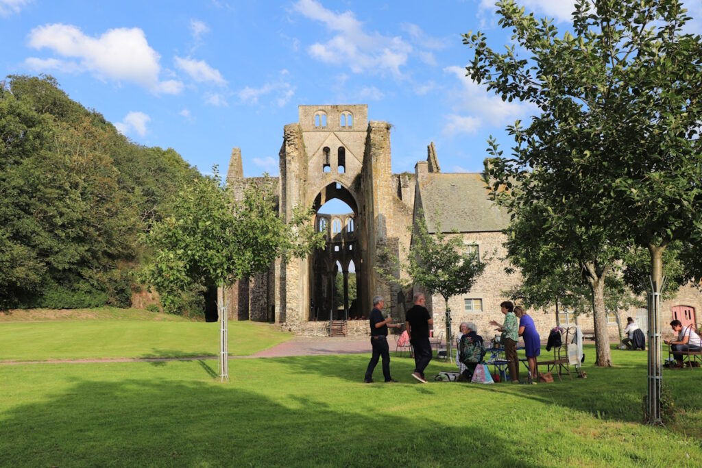 Un groupe de personne pique-nique devant l'église abbatiale par un beau jour d'été