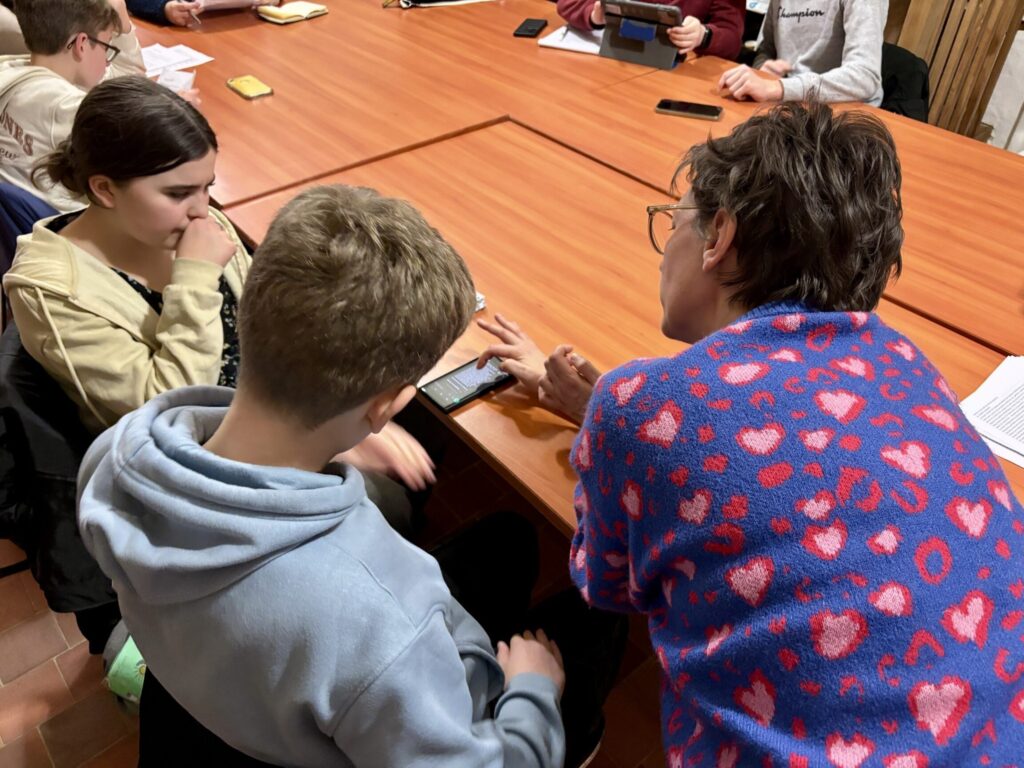 Les collégiens travaillent sur leur projet dans la salle de réunion de l'abbaye avec Vanessa.